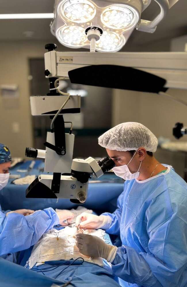 Dr. João Cunha Thomaz realizando microcirurgia com microscópio